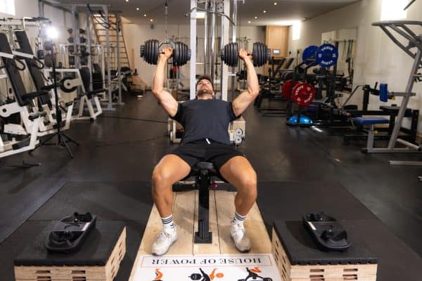 Dumbbell training met verstelbare 24 kg dumbbell in fitnessruimte.